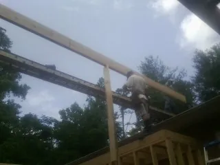 Carpenter setting a ridge beam over a new addition frame — Ice Dam Removal by Roofing Brothers in North Haven