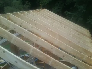 New roof rafters set over an addition before sheathing in North Haven