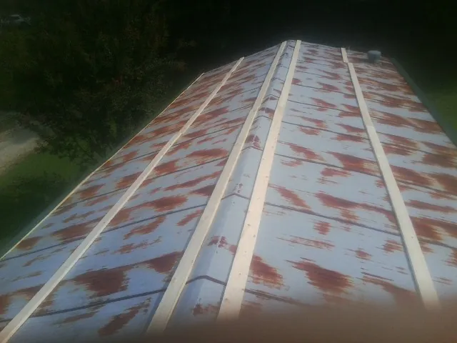 Rusted metal roof panels with new wood purlins before replacement — Storm Damage Roof Repair in North Haven by Roofing Brothers