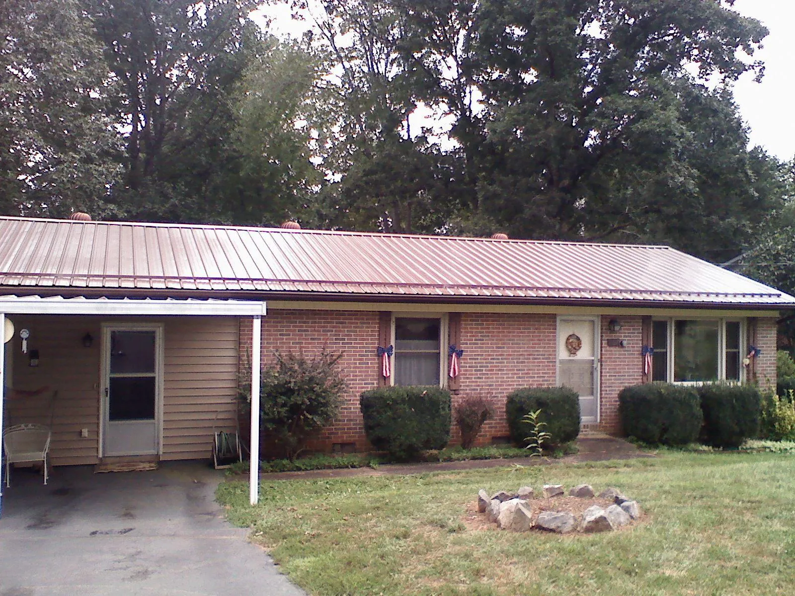 Bronze metal roof and carport on a brick ranch home — Roof Repair work by our crew in North Haven
